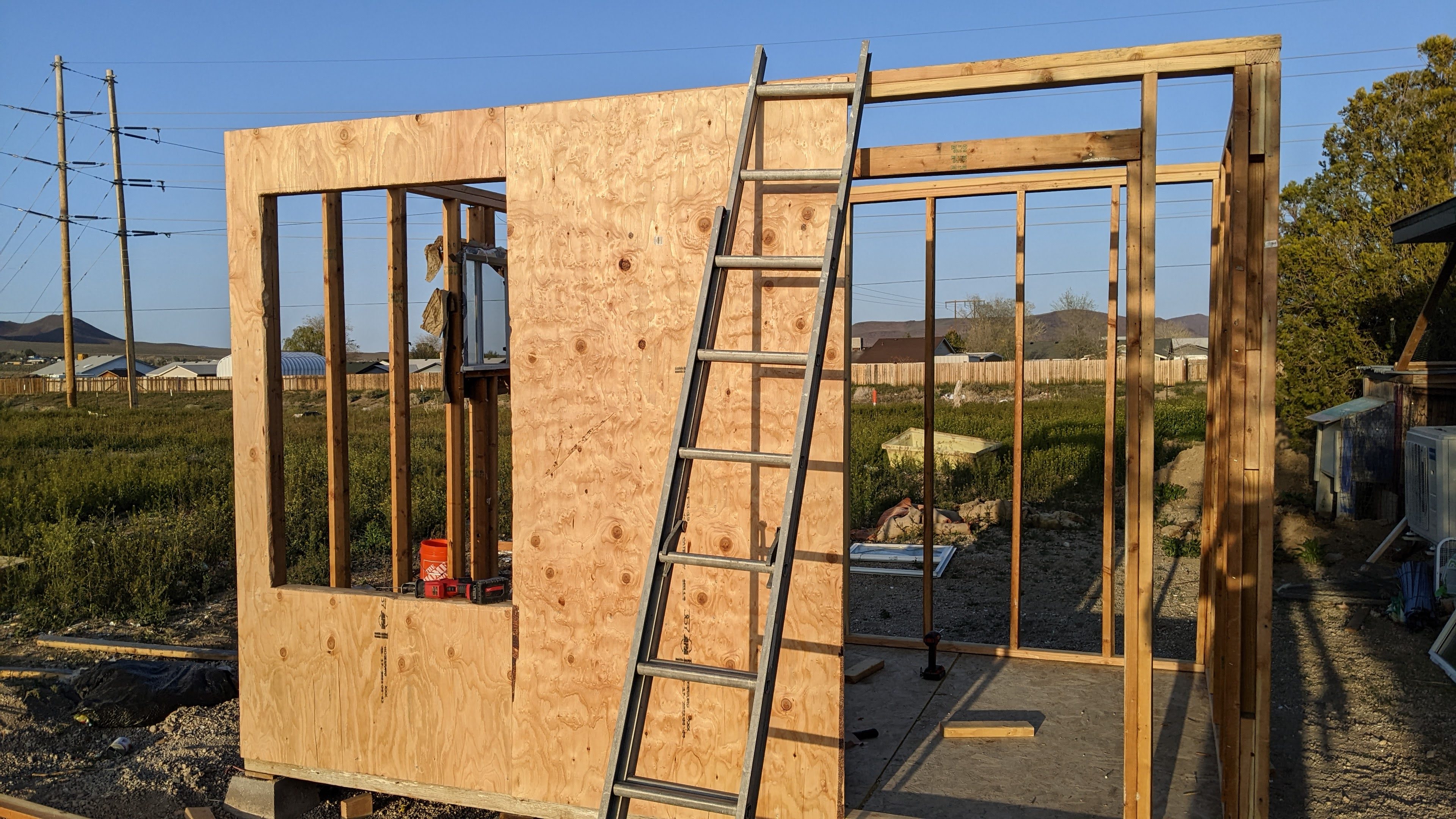 A stick frame building with plywood sheathing on part of it..